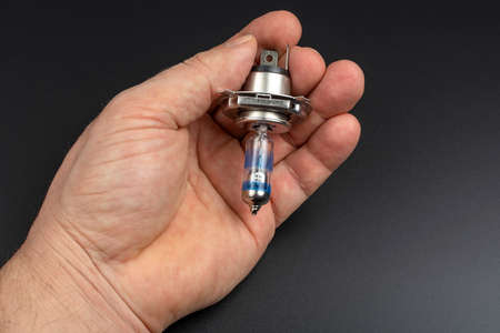 close-up of a blue light bulb head light in a man's handの写真素材