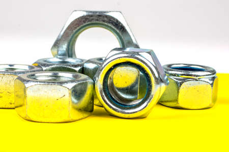 metal bolts and nuts on yellow backgroundの写真素材
