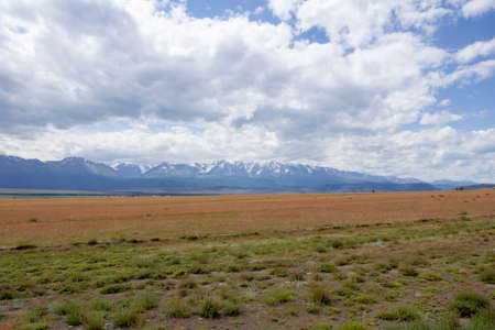 snowy peaks of mountains and steppe on a background of cloudy skyの写真素材