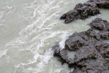 rough mountain river Katun is sandwiched by stone banksの写真素材