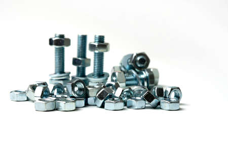 several large nuts and bolts in a group on a white backgroundの写真素材