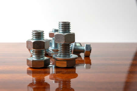 a few bolts and nuts on a polished wooden tableの写真素材