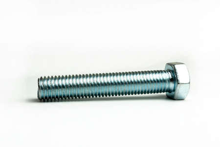 Large metal bolt lies on a white backgroundの写真素材