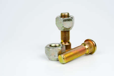 metal stud and shiny car wheel nuts close-up on a white background. car spare part