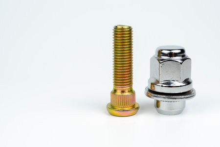 metal stud and shiny car wheel nuts close-up on a white background. car spare part