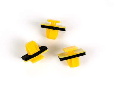 Plastic yellow clips for cars. Close up. Isolated on white background
