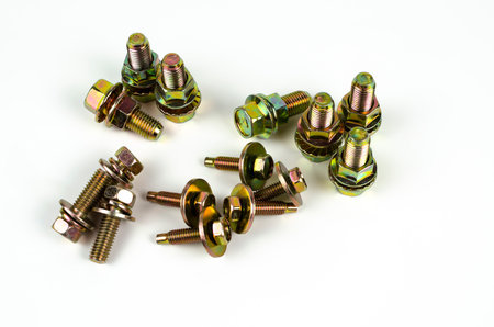 Group of metal bolts with yellow nuts. Close up. Isolated on white backgroundの写真素材