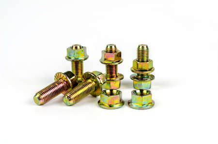 Metal bolts with yellow nuts. Close up. Isolated on white background