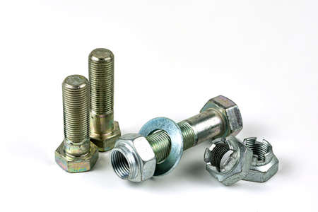 Large metal nuts with silver metal bolts. Close-up on a white background. A group of several nuts...