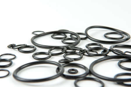 Black hydraulic and pneumatic o-rings in different sizes on a white background. O-rings for hydraulic connections. Rubber seals for sanitary ware. Copy spaceの写真素材