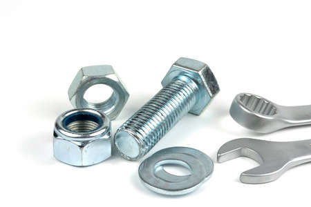 A small group of silver fasteners for fastening structures. Bolts and nuts with washers close-up on...