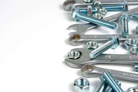 several open-end metal wrenches for working with bolts. Close-up on a white background. Silver metal fixing bolts and nuts. Copy spaceの写真素材