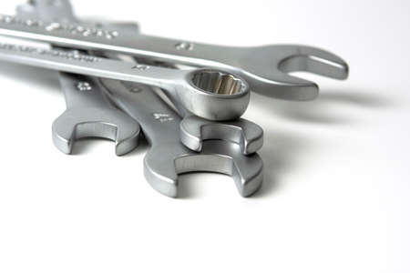 several open metal keys are in a pile. Close-up on white background