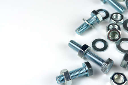 metal bolts and nuts with round washers close-up on a white background. copy space