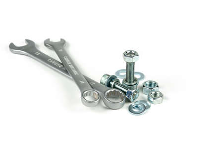 New repair tool, bolts and nuts close-up on a white background. Tool for connecting a threaded...