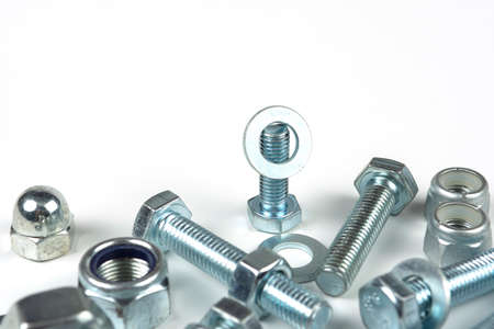 metal bolts and nuts with round washers close-up on a white background. copy space