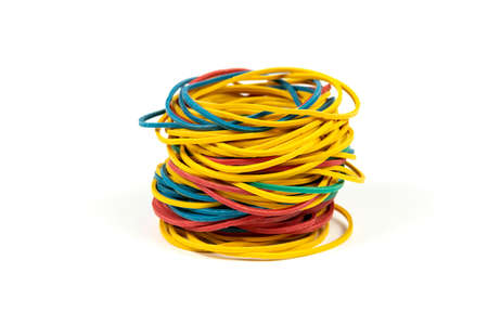 Colored rubber bands for money stacked in a high pile against white background