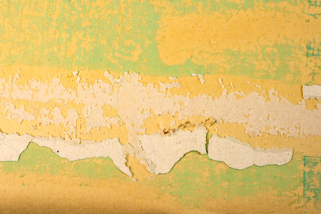 Green damaged plaster on concrete wall, old plaster needs repair. Abstract background, close-up, copy spaceの写真素材