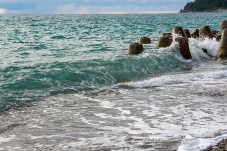 Splash of sea waves crashing on a pebble beach. Warm summer evening on the Black Sea coast. Abkhazia, a beautiful place for restの写真素材