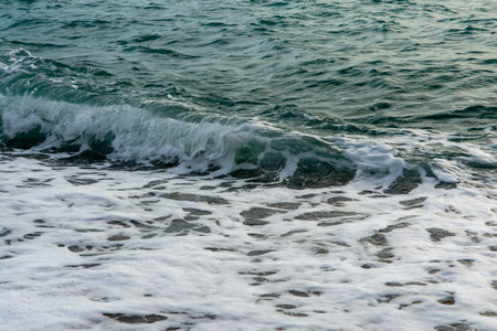 Splash of sea waves crashing on a pebble beach. Warm summer evening on the Black Sea coast. Abkhazia, a beautiful place for restの写真素材