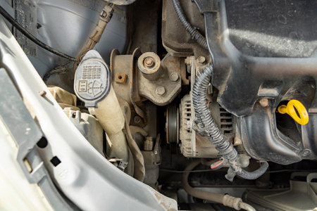 Detailed view of a modern car engine with exposed elements under the hood. Close-ups of various mechanical parts and liquid containers. sunny bright dayの写真素材