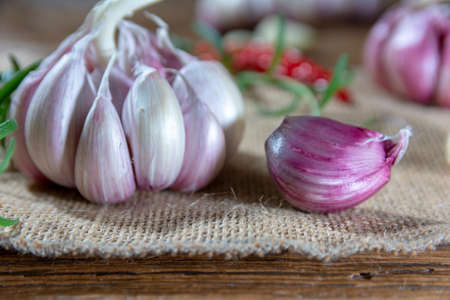 garlic bulbs and cloves arranged on an old board.の写真素材