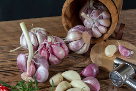 garlic bulbs and cloves arranged on an old board.の写真素材