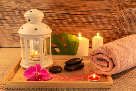 Spa, zen basalt stones, towels, candles on a wooden tray in the massage room.の写真素材