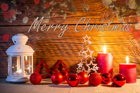 Christmas decoration. A festive lantern against an old wooden wall, surrounded by Christmas balls.の写真素材