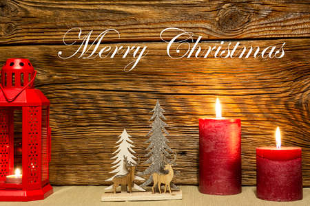 Christmas decoration. A festive lantern against an old wooden wall, surrounded by Christmas balls.の写真素材