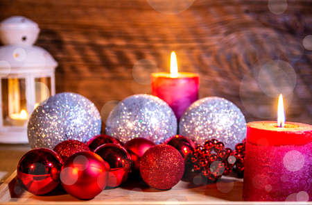 Christmas decoration. A festive lantern against an old wooden wall, surrounded by Christmas balls.の写真素材