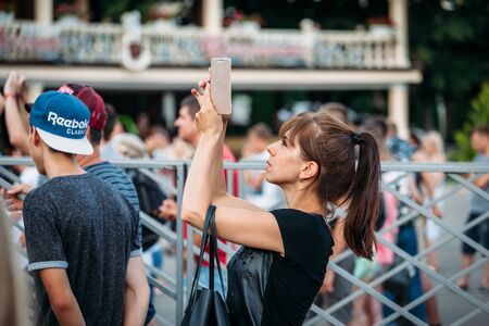 Yessentuki, Stavropol Territory / Russia - August 12, 2017: woman at a concert shoots on the phone outdoorsのeditorial素材