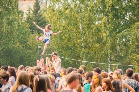 Kemerovo, Russia, June 24, 2018: A young girl at the festival of colors Holi thrown up