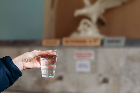Yessentuki, Stavropol Territory / Russia - February 26, 2019: Drinking gallery of mineral spring Essentuki â 17. indoors. young woman holding a glass of mineral waterのeditorial素材