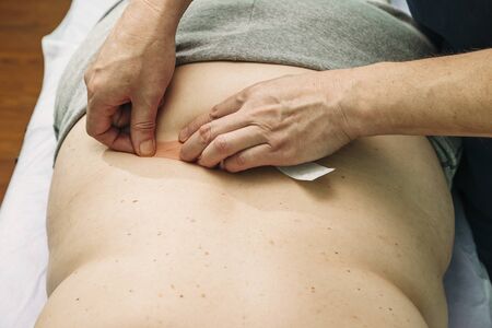 physical therapist applying elastic therapeutic tape or kinesiology tape kinesio tapeの写真素材