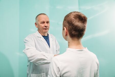 doctor in white coat examines the boy's patientの写真素材