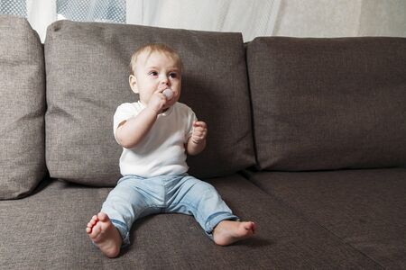 little baby crying on the couch at home close up