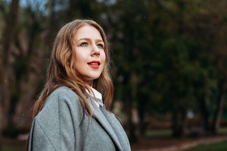 Portrait of a happy young girl smiling businesswoman walking in Park in autumn. copy spaceの写真素材