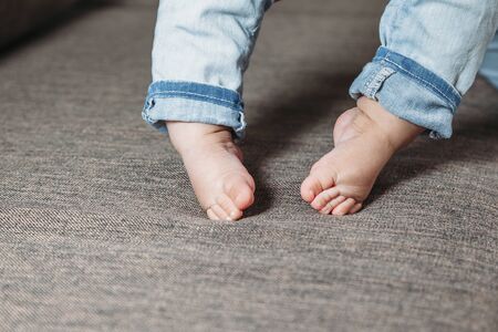 baby's first steps. The baby's feet take the first steps. photo of children's legs barefoot.