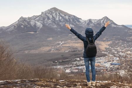 hiker in mountains with arms raised in airの写真素材