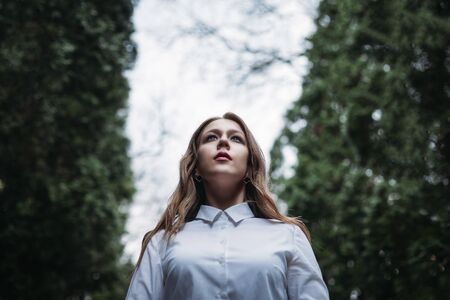 Young business woman, employee standing in the Park rain, bottom view. copy spaceの写真素材