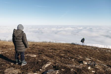 people at the top of the mountain take pictures of paragliders and beautiful views above the cloudsの写真素材