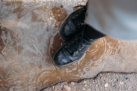 closeup of shoes in a puddle. the view from the top. protect the shoes from moisture.の写真素材