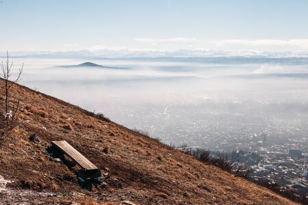 view from the mountains to the mountains and city in the cloudsの写真素材