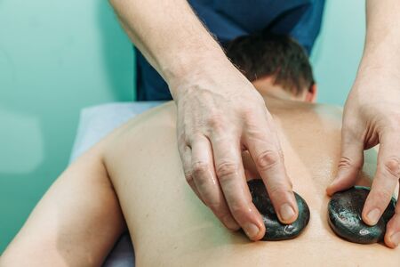 stone massage man getting stone therapy massage at the cabinetの写真素材