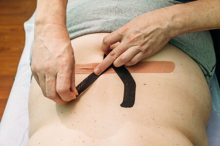 physical therapist applying elastic therapeutic tape or kinesiology tape kinesio tapeの写真素材