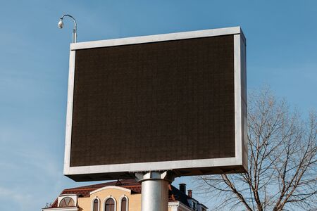 Billboard with empty screen, against blue sky