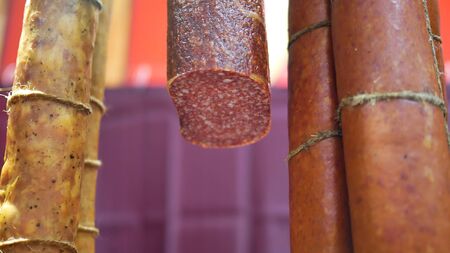 Cut smoked sausage hanging in the shop.