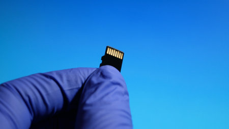 The technician worker holding in micro SD card repairing in service center on blue background.の写真素材