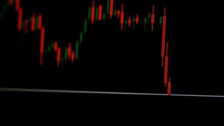 The collapse of prices on the stock chart on the screen on a black background. The concept of crisis in the stock marketの写真素材
